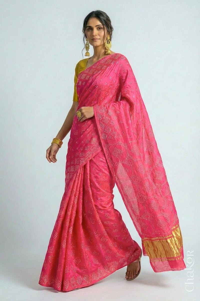 Model wearing Handcrafted Coral Pink Bandhani Gaji Silk Saree with rai bandhej patterns and tissue pallu.