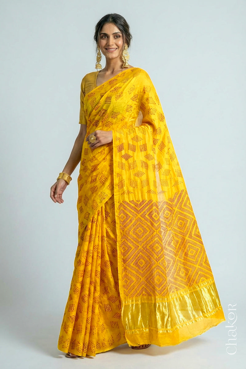 Model wearing Yellow Red Bandhani Gaji Silk Saree, handcrafted with red rai bandhej motifs and lagdi patto pallu.