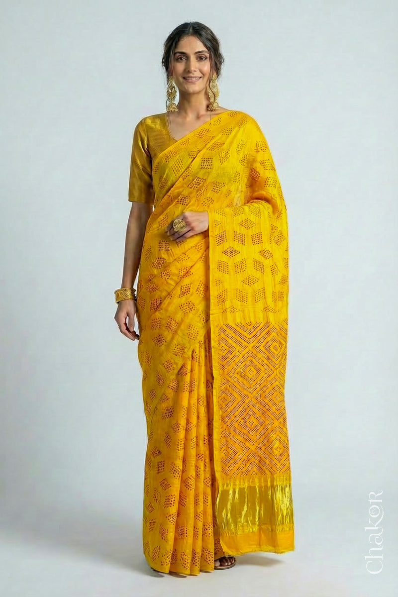 Model wearing Yellow Red Bandhani Gaji Silk Saree, handcrafted with red rai bandhej motifs and lagdi patto pallu.