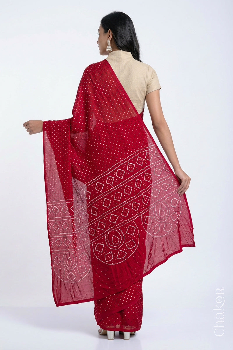 Back view of model wearing Red Bandhani Mulberry Silk Saree, handcrafted in rai bandhej patterns with mukaish embroidery.
