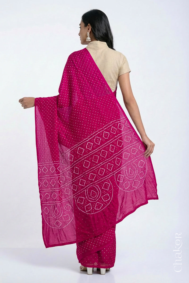 Back view of model wearing Rani pink Bandhani Mulberry Silk Saree, handcrafted in rai bandhej patterns with mukaish embroidery.