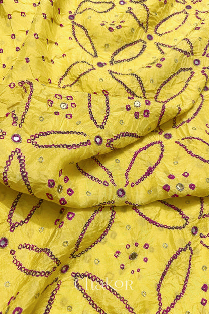 Close-up of Yellow mulberry silk Bandhani (Rai Bandhej) fabric with rani pink tie-dye motifs, zari embroidered pink mirror work and sequin detailing – CHAKOR.
