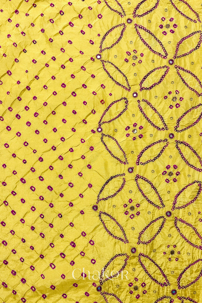 Yellow mulberry silk Bandhani (Rai Bandhej) fabric showing full layout with rani pink tie-dye dots, floral bandhej pattern, and pink with zari mirror & sequins embroidery – CHAKOR.
