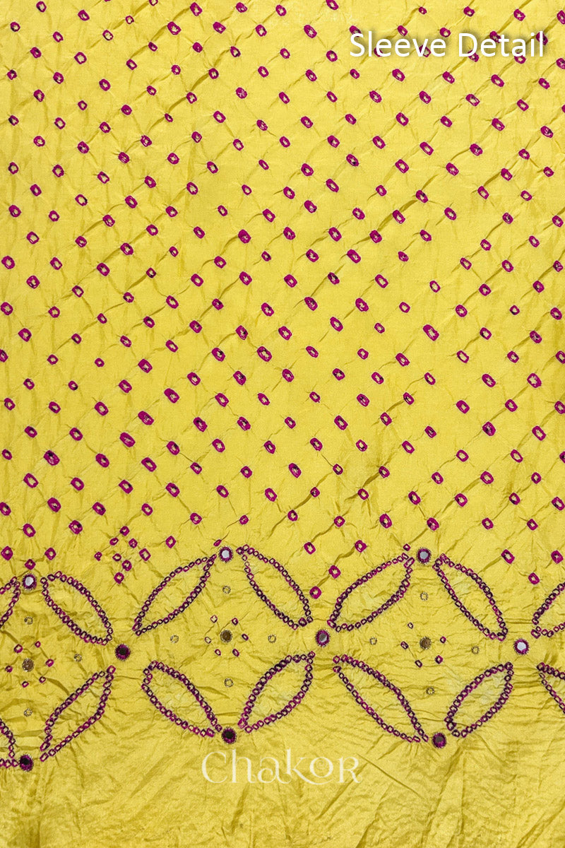 Sleeve detail of Yellow mulberry silk Bandhani (Rai Bandhej) fabric with rani pink dots, floral bandhej borders and pink with zari mirror embroidery – CHAKOR.
