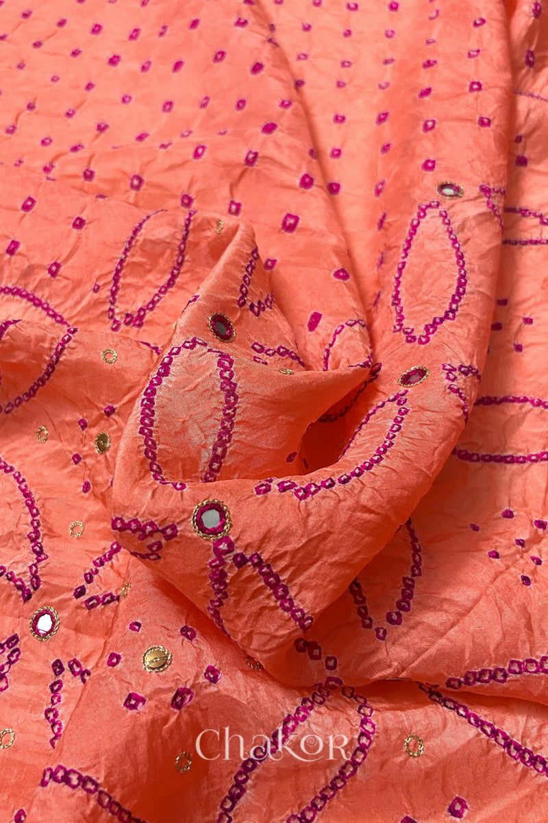 Close-up of Coral pink mulberry silk Bandhani (Rai Bandhej) fabric with rani pink tie-dye motifs, zari embroidered pink mirror work and sequin detailing – CHAKOR.
