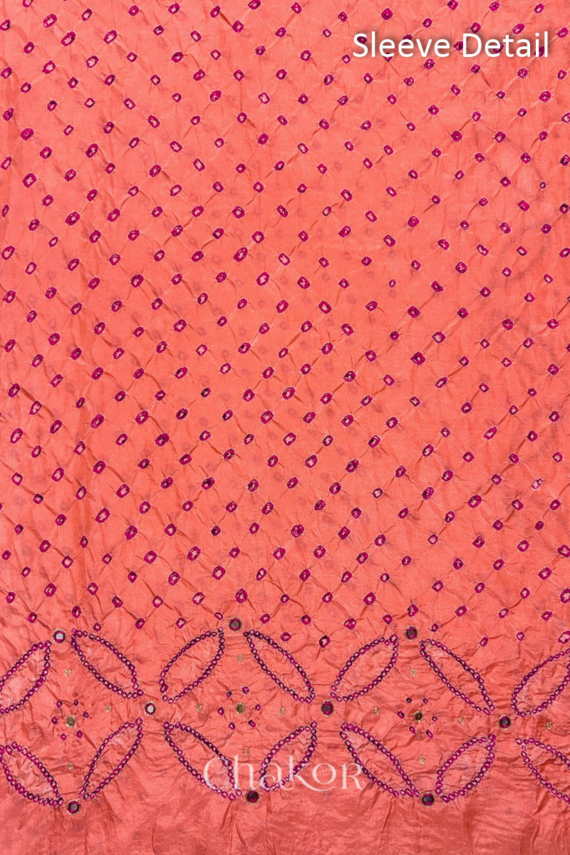 Sleeve detail of Coral pink mulberry silk Bandhani (Rai Bandhej) fabric with rani pink dots, floral bandhej borders and pink with zari mirror embroidery – CHAKOR.
