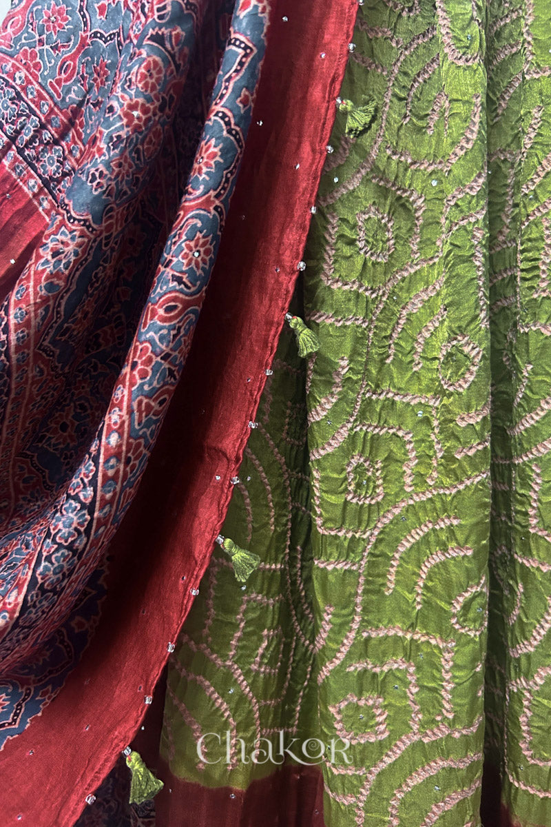 Close-up of leaf green Bandhani gaji silk dupatta showing Ajrakh pallu alongside body pattern.