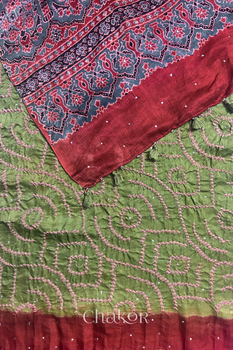 Flat detail view of leaf green Bandhani gaji silk dupatta showing body pattern and ajrakh printed pallu edge.