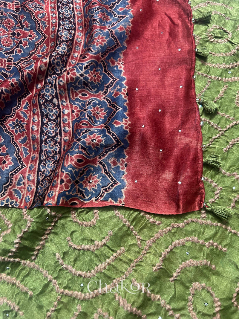 Close-up of Ajrakh printed pallu on leaf green Bandhani gaji silk dupatta with mukaish embroidery and tassel details.