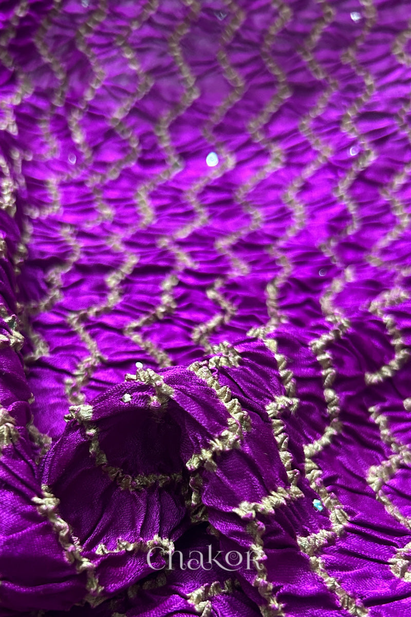 Detail of magenta Bandhani gaji silk dupatta showing tie-dye pattern with shimmer of metallic embellishments.