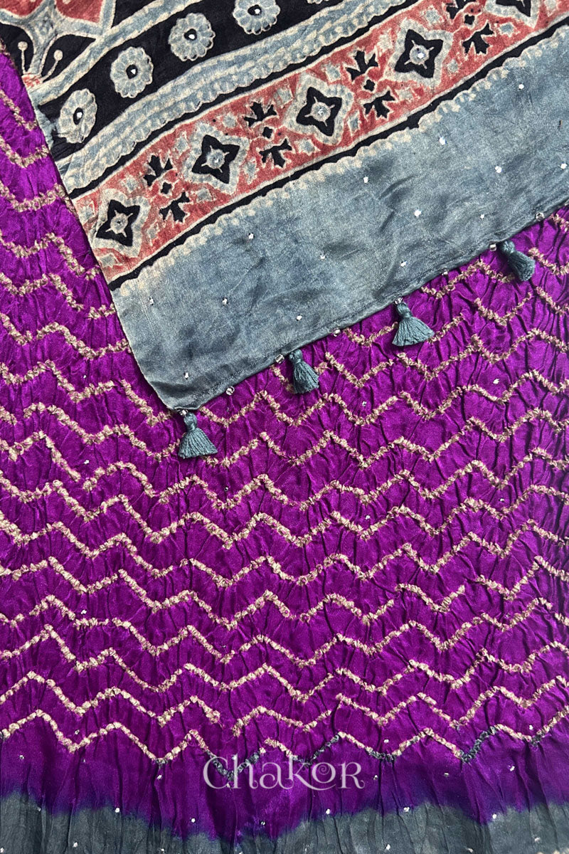 Detail of magenta Bandhani gaji silk dupatta with Ajrakh printed Indigo pallu edged with tassels and beads.