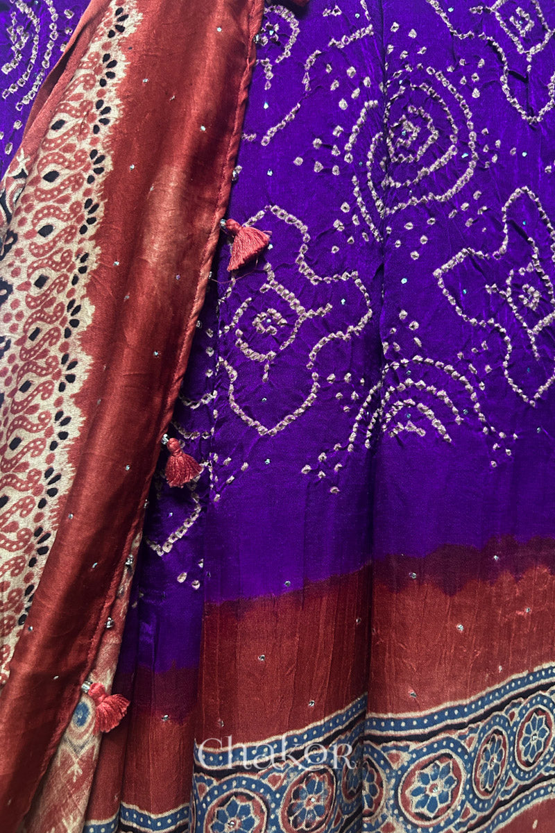 Detail view of purple Bandhani gaji silk dupatta featuring mukaish embroidery and Ajrakh pallu edged with tassels