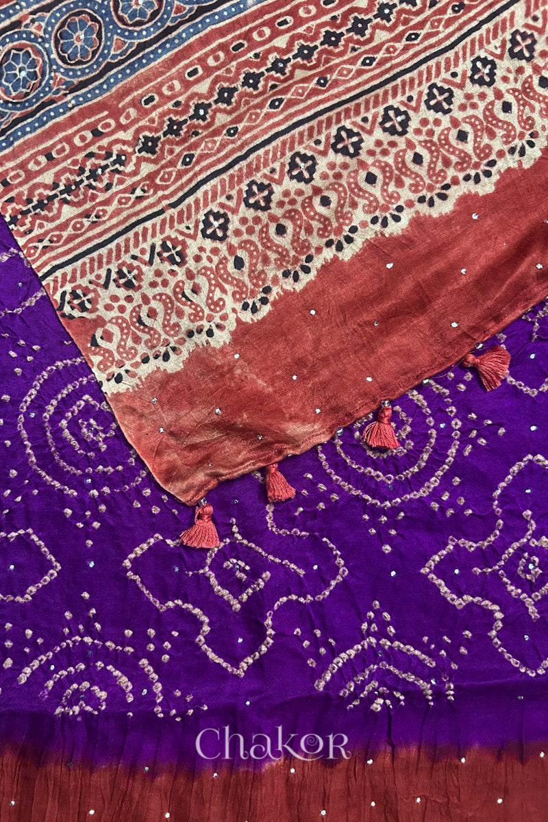 Pallu edge detail of purple Bandhani gaji silk dupatta with Ajrakh print and tassels.