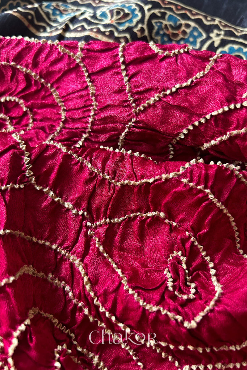 Close up of Red Bandhani Saree with Black Ajrakh printed border and pallu in pure gaji silk with traditional bandhej tie-dye, handcrafted in Kutch. 