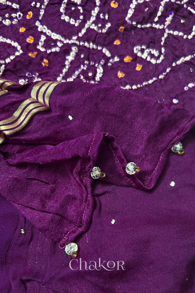 Close-up of a rai bandhej dupatta in magenta featuring beads detail on the folded hem.Text reads Chakor brand watermark.
