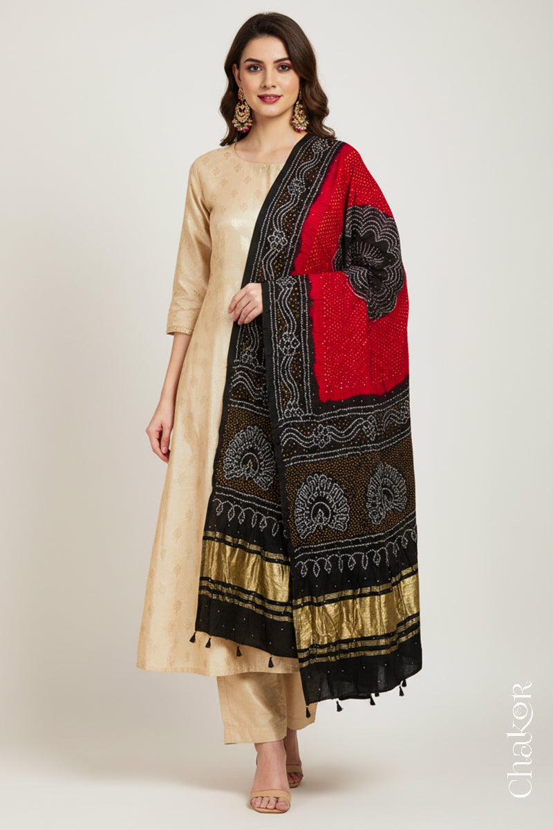 Model wearing Red black bandhani gaji silk dupatta with mukaish embroidery & tassels handcrafted in kutch by CHAKOR on a beige kurta set.