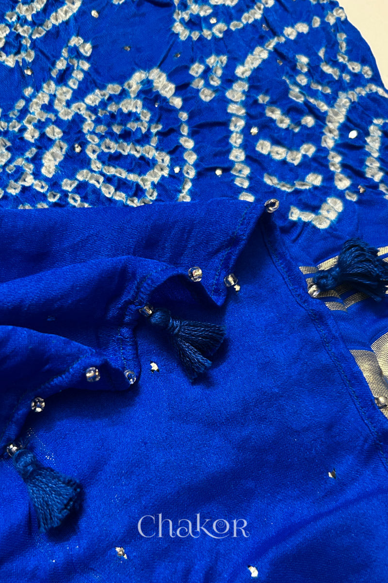 Close-up of a rai bandhej dupatta in blue ombre featuring tassel detail on the folded hem.Text reads Chakor brand watermark.
