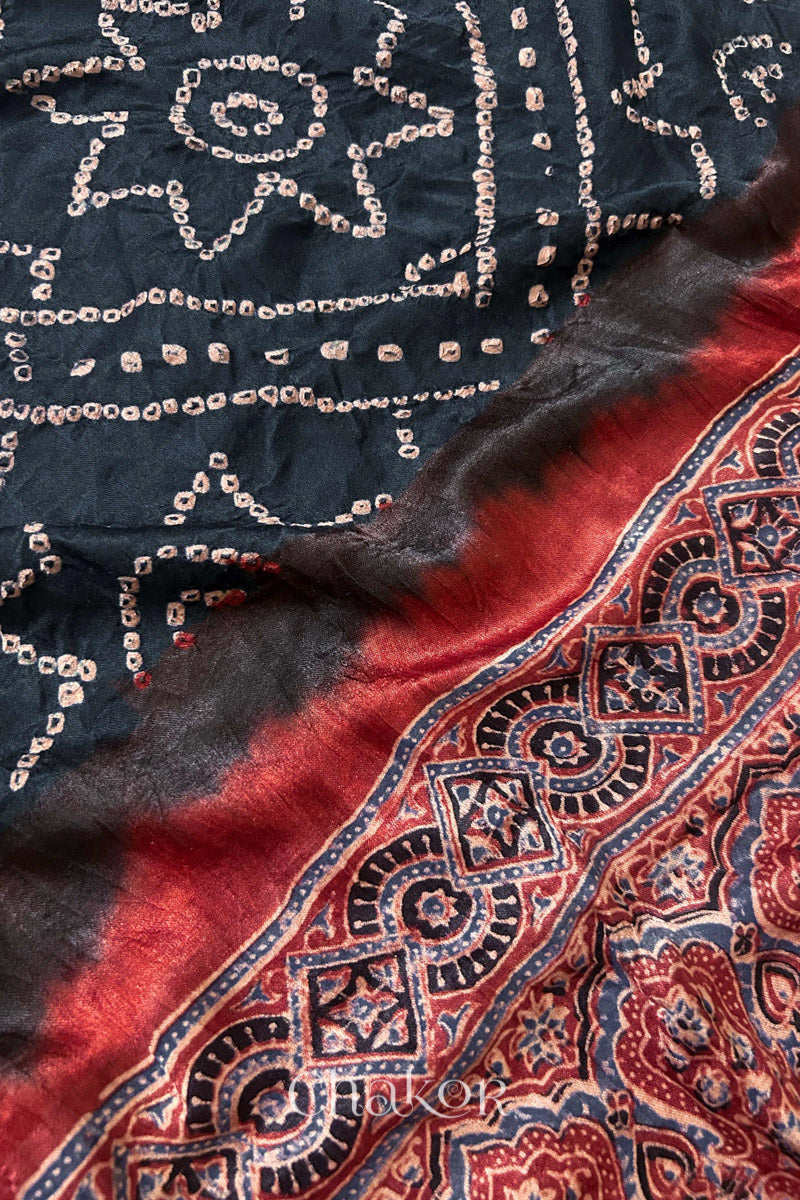 Close up of Black Bandhani Saree with Natural Red Ajrakh printed border and pallu in pure gaji silk with traditional bandhej tie-dye, handcrafted in Kutch. 