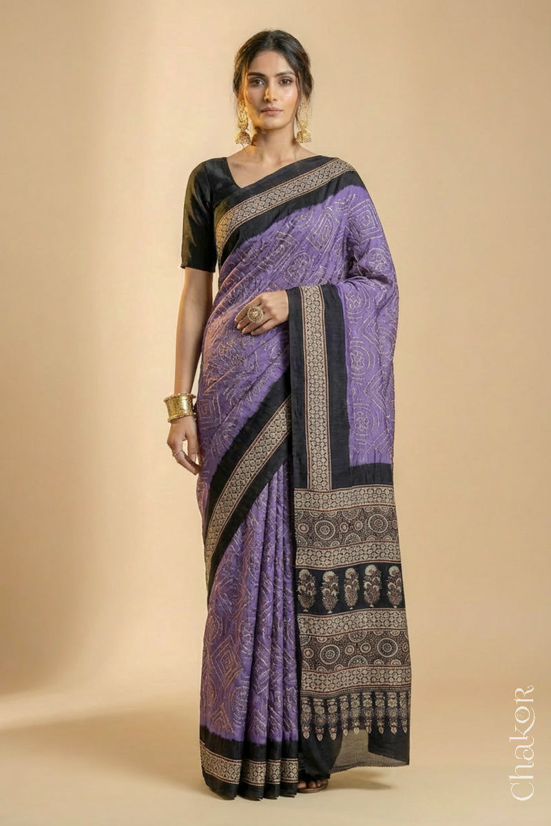 Woman wearing Mauve Bandhani Saree with Natural Black Ajrakh printed border and pallu in pure gaji silk with traditional bandhej tie-dye, handcrafted in Kutch. 