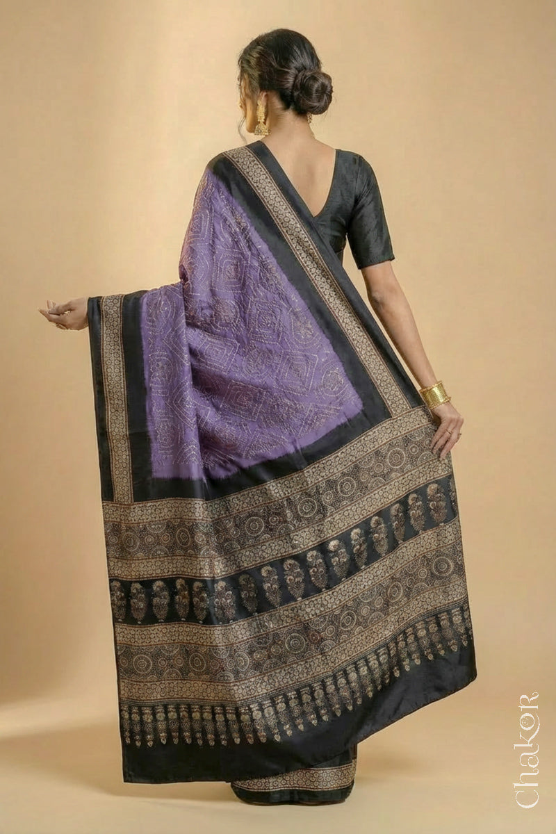 Woman wearing Mauve Bandhani Saree with Natural Black Ajrakh printed border and pallu in pure gaji silk with traditional bandhej tie-dye, handcrafted in Kutch. 