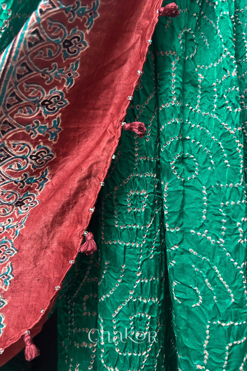 Close-up of jade green Bandhani gaji silk dupatta showing Ajrakh border and pallu transition.