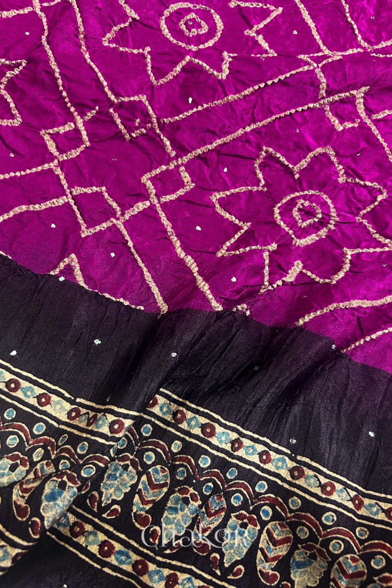 Close up of Magenta Bandhani Saree with Natural Black Ajrakh printed border and pallu in pure gaji silk with traditional bandhej tie-dye & mukaish embroidery, handcrafted in Kutch. 