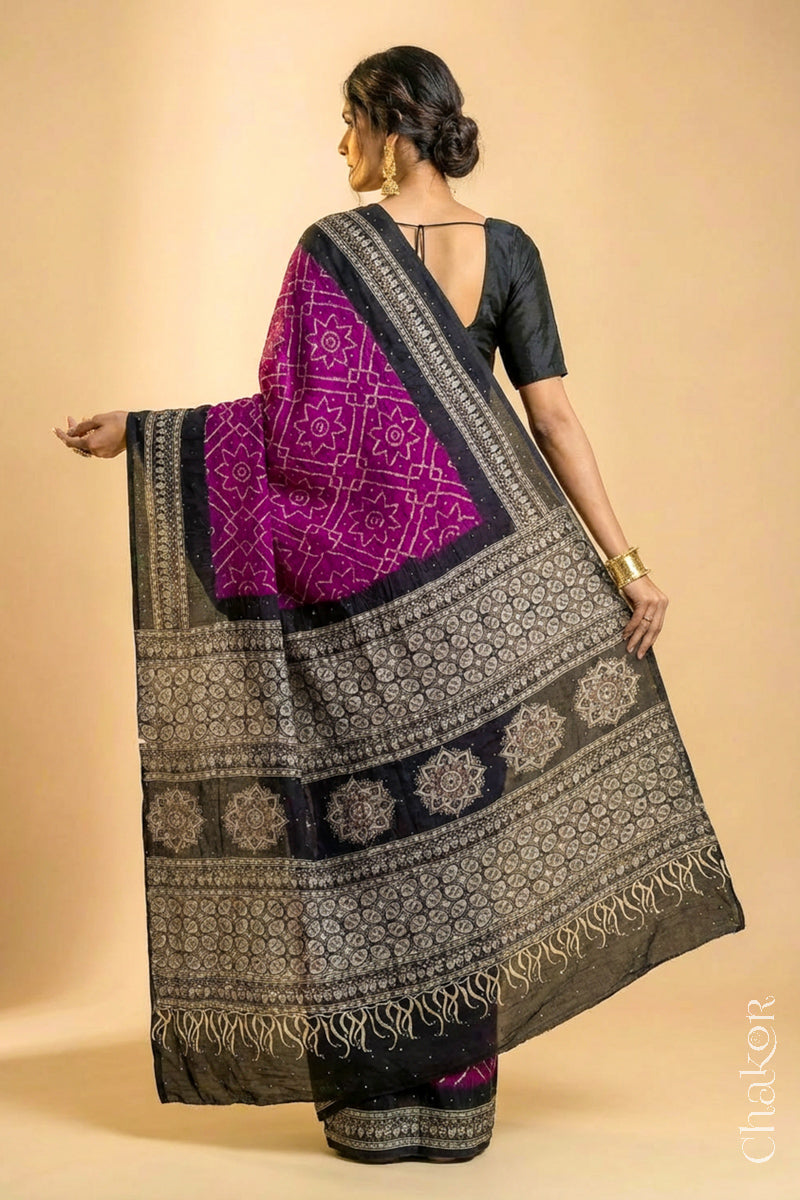 Woman wearing Magenta Bandhani Saree with Natural Black Ajrakh printed border and pallu in pure gaji silk with traditional bandhej tie-dye & mukaish embroidery, handcrafted in Kutch. 