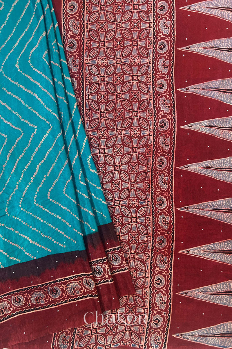Close up of Peacock Blue Bandhani Saree with Natural Red Ajrakh printed border and pallu in pure gaji silk with traditional bandhej tie-dye & mukaish embroidery, handcrafted in Kutch. 