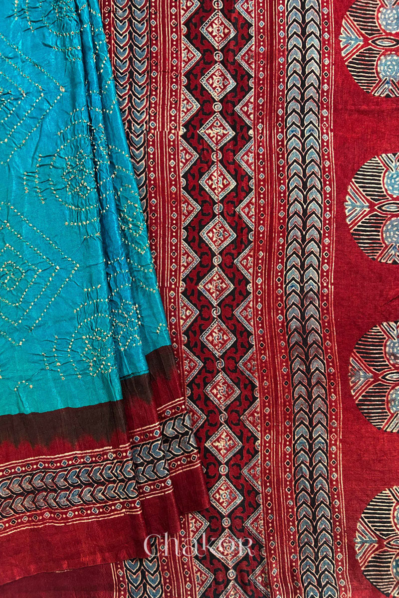 Close up of Peacock Blue Bandhani Saree with Natural Red Ajrakh printed border and pallu in pure gaji silk with traditional bandhej tie-dye, handcrafted in Kutch. 
