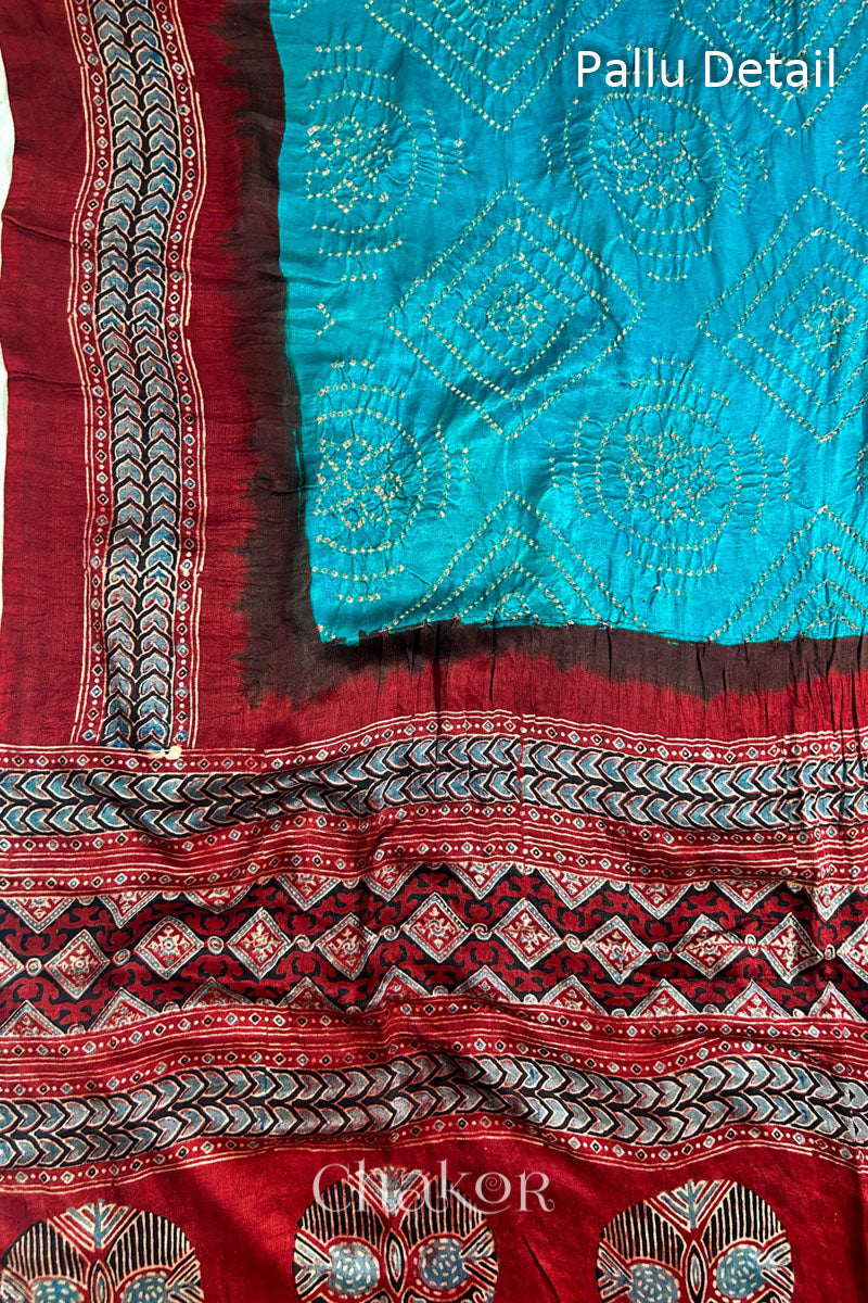 Close up of Peacock Blue Bandhani Saree with Natural Red Ajrakh printed border and pallu in pure gaji silk with traditional bandhej tie-dye, handcrafted in Kutch. 