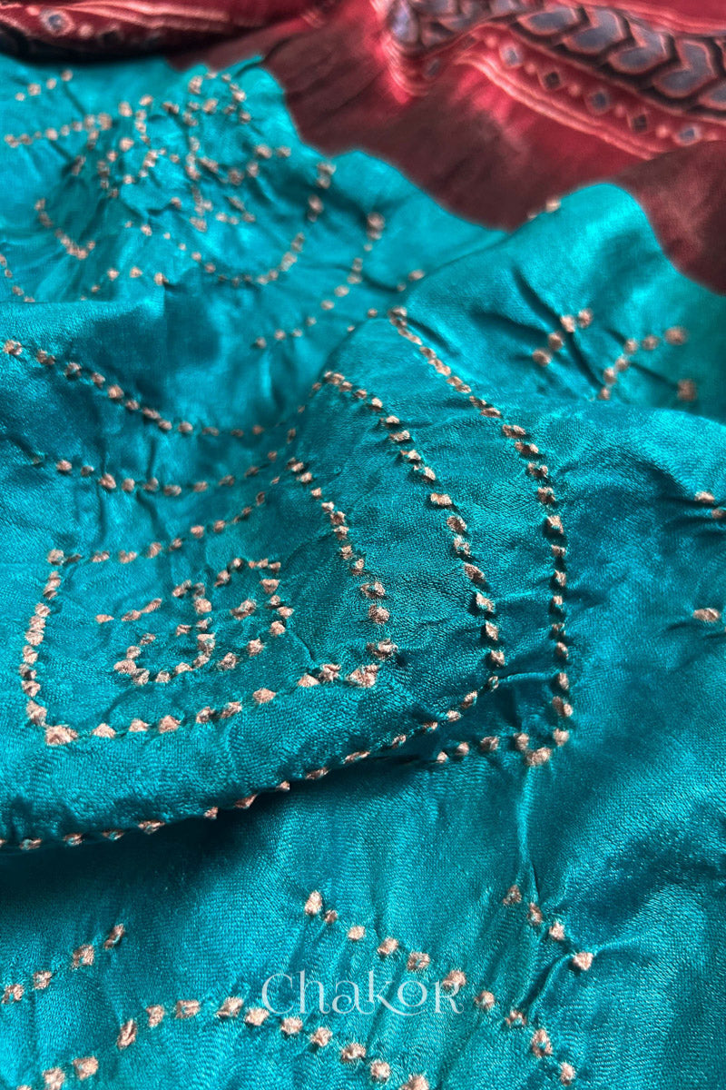 Close up of Peacock Blue Bandhani Saree with Natural Red Ajrakh printed border and pallu in pure gaji silk with traditional bandhej tie-dye, handcrafted in Kutch. 
