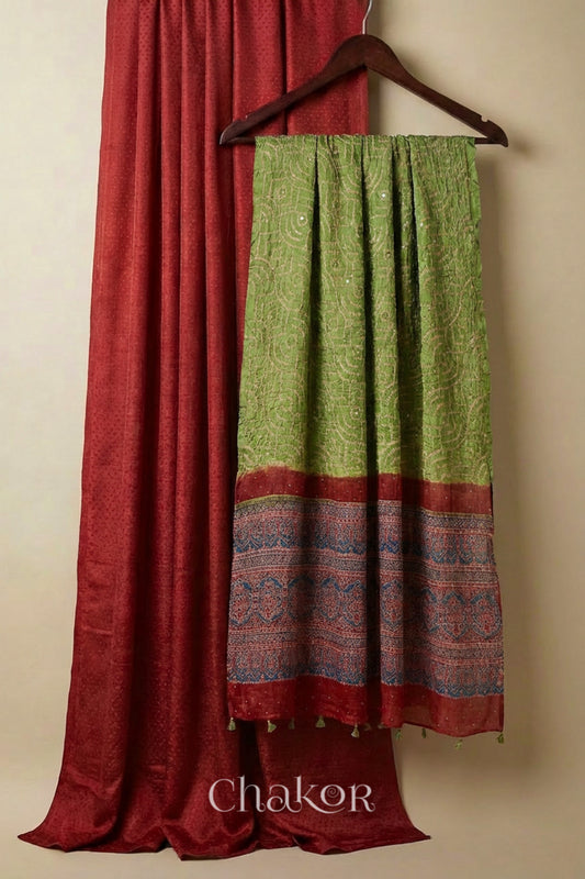 Brick red mashru kurta set fabric styled with green bandhani silk hand embroidered dupatta and ajrakh printed pallu.