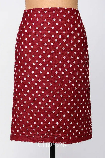 Bottom fabric in red patterned with simple bandhani tie dye dots, draped neatly on a dress form, with Chakor brand logo.
