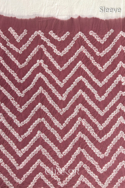 Close-up of soft rose pink bandhani fabric featuring chevron tie-dye design, with Chakor brand logo. Text reads sleeve details.