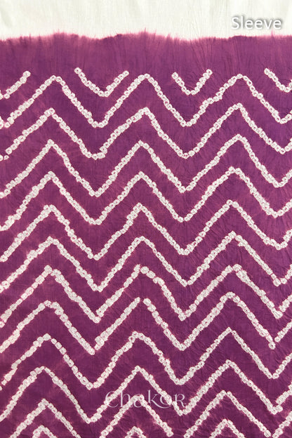 Close-up of deep violet bandhani fabric featuring chevron tie-dye design, with Chakor brand logo. Text reads sleeve detail.