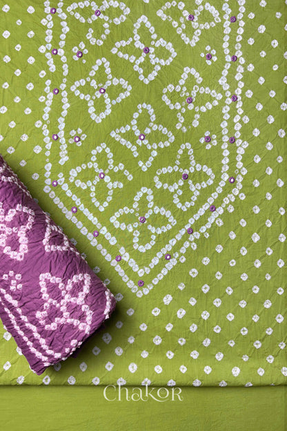 Front yoke detail of Green Bandhani cotton kurta fabric with hand embroidery and mirror work and Mauve dupatta rolled up.
