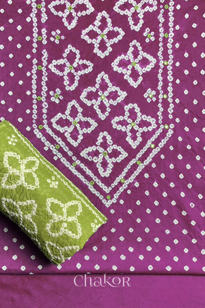 Front yoke detail of Mauve Bandhani cotton kurta fabric with hand embroidery and mirror work and Lime Green dupatta rolled up.
