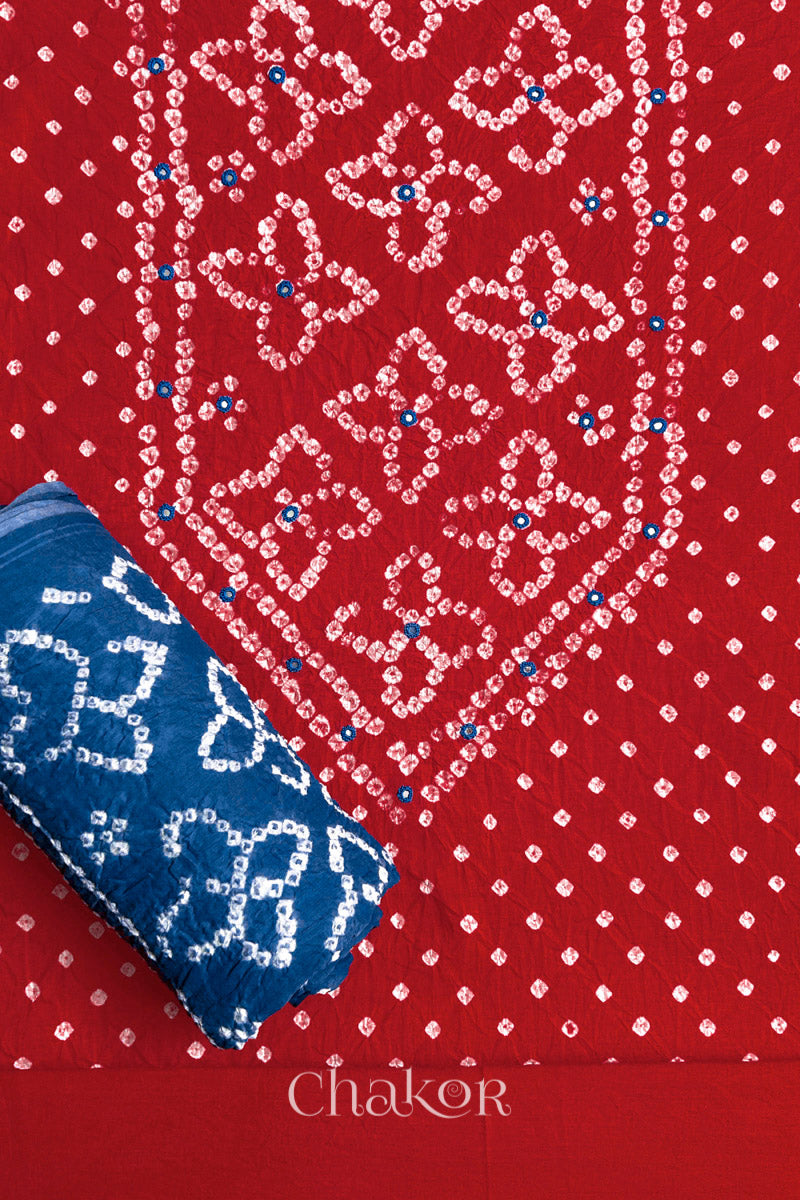 Front yoke detail of Red Bandhani cotton kurta fabric with hand embroidery and mirror work and Indigo Blue dupatta rolled up.
