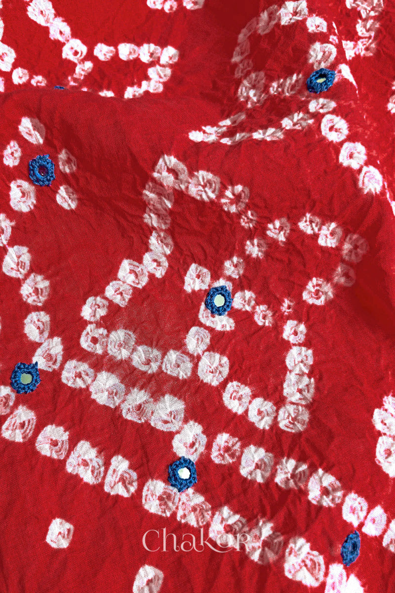 Hand tied Bandhani floral motif with colourful mirror embroidery on Red cotton fabric.
