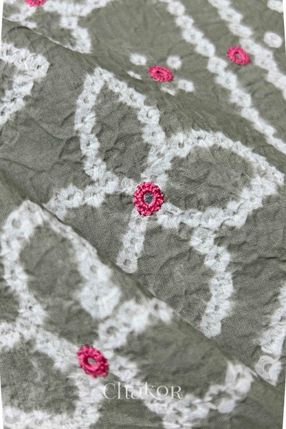 Close-up of Bandhani floral pattern accented with hand embroidery Grey mirror work.
