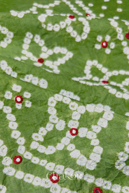 Hand tied Bandhani floral motif with colourful mirror embroidery on Green cotton fabric.
