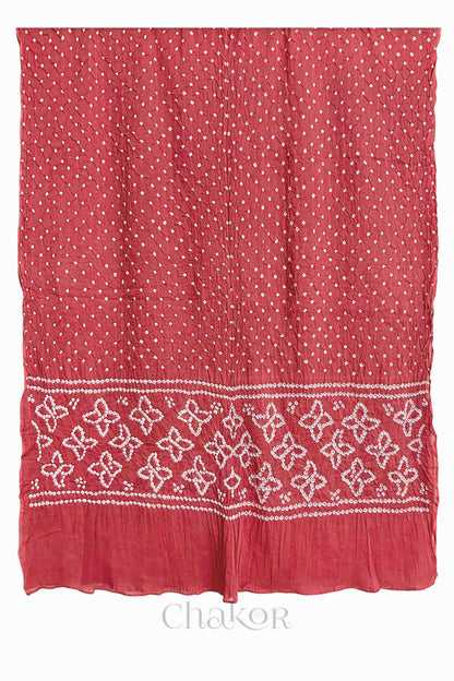 Full view of Dusty Red Bandhani mulmul cotton dupatta with floral pallu and dotted body pattern.
