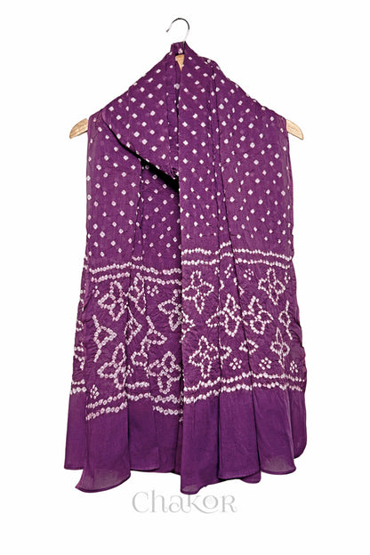 Mauve mercerised mulmul cotton dupatta with Bandhani floral pallu design draped on hanger.
