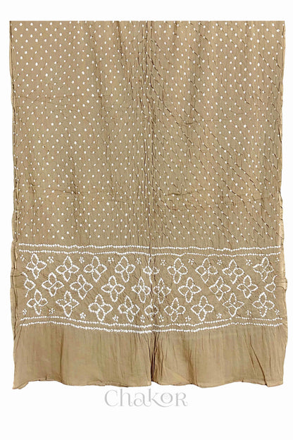 Full view of Beige Bandhani mulmul cotton dupatta with floral pallu and dotted body pattern.
