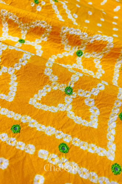 Hand tied Bandhani floral motif with colourful mirror embroidery on Yellow cotton fabric.
