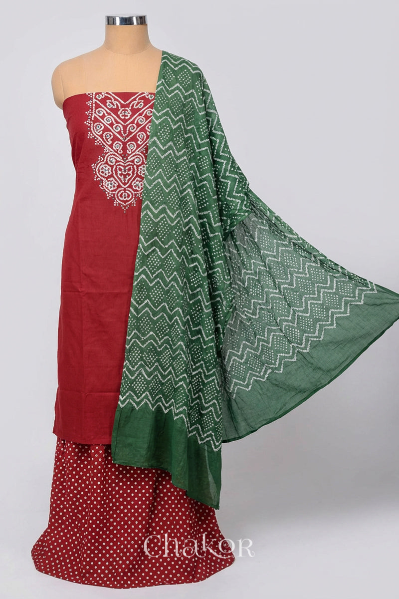 A stylish brick red bandhani kurta set fabric featuring mirror embroidered yoke, bandhani bottom and contrast moss green dupatta draped on a dressform.
