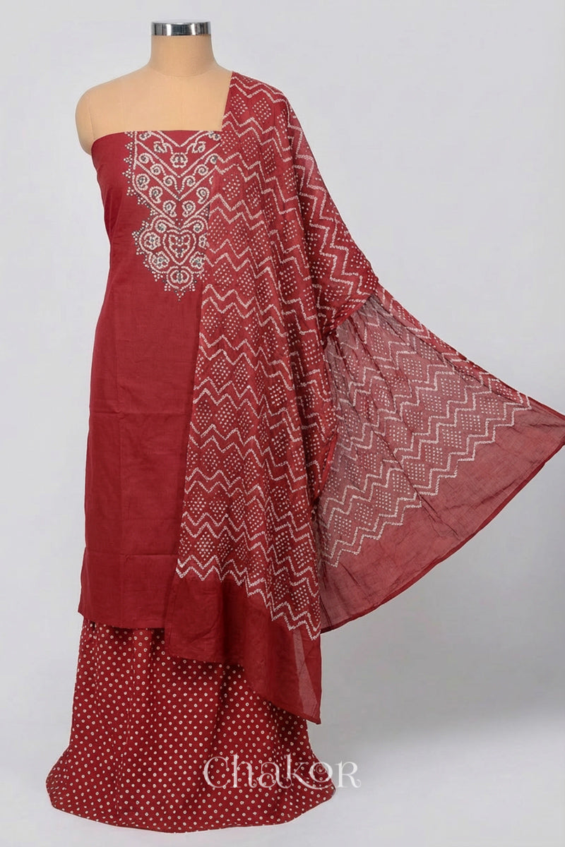 A stylish brick red bandhani kurta set fabric featuring mirror embroidered yoke, matching coloured bandhani bottom and dupatta draped on a dressform.