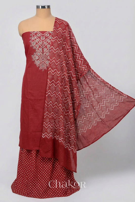 A stylish brick red bandhani kurta set fabric featuring mirror embroidered yoke, matching coloured bandhani bottom and dupatta draped on a dressform.