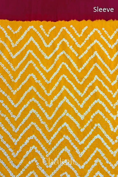 Close-up of yellow bandhani fabric featuring chevron tie-dye design, with Chakor brand watermark. Text reads sleeve.
