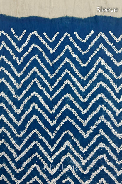Close-up of  indigo blue bandhani fabric featuring chevron tie-dye design, with Chakor brand watermark. Text reads sleeve.
